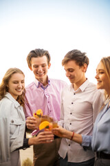 Crop happy friends drinking cocktails together