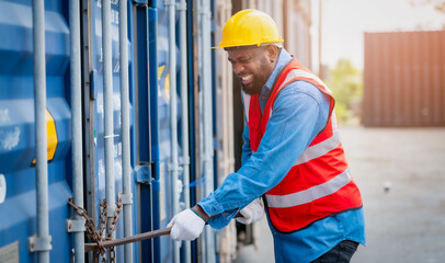 Portrait of African Engineer or foreman wears PPE checking container storage with cargo container...