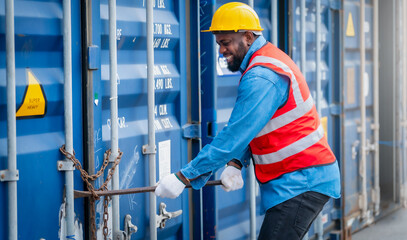 Portrait of African Engineer or foreman wears PPE checking container storage with cargo container...