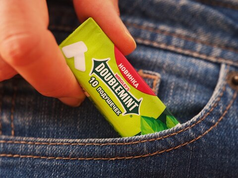 Tambov, Russian Federation - December 20, 2023 A woman taking a Wrigleys Doublemint chewing gum pack out of  jeans pocket.