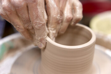 male hands making ceramic cup on pottery wheel, Close-up