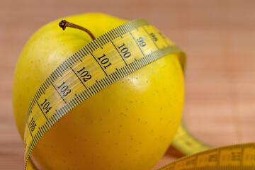 Apfel und Maßband symbolisch für Gewichtsreduzierung