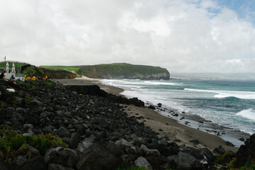 ocean waves wash the rocky shore and beach Santa Barbara on the island of San Miguel, Azores