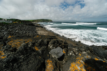 ocean waves wash the rocky shore and beach Santa Barbara on the island of San Miguel, Azores