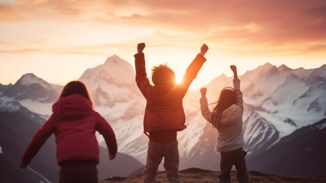 Out of focus image of three kids cheering in front of magical sunset in mountains, success and achievement concepts