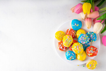 Homemade Italian Easter cookies with colorful sugar glaze and sprinkles, on white kitchen table...