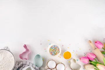  Easter baking background, ingredient for making Easter cookies, cakes, dessert with Easter chocolate eggs, sugar sprinkles, baking ingredients, flour, egg, milk, rolling pin, spring flowers top view © ricka_kinamoto