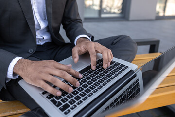 Close up of a businessman typing on laptop