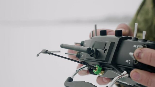 FPV drone operator, close-up, hands holding the remote control.