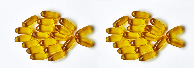 Fish oil omega 3 yellow capsules on white background. Organic vitamins and supplements concept. Top...