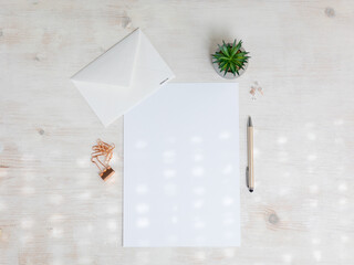 Paper A4 empty on wooden table with paper clips, envelope, pen, plant. Office stationery mockup flat lay. - 715844273
