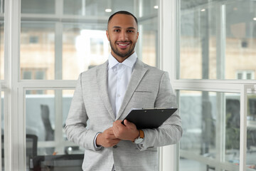 Fototapeta premium Happy man with clipboard in office. Lawyer, businessman, accountant or manager