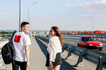 Happy couple walking along bridge