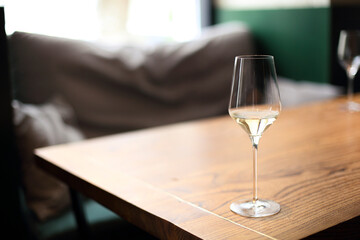 Transparent drink in glass goblet on wood background