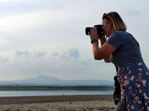 woman traveler taking pictures of mountain lake