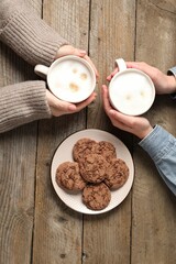Women having coffee break at wooden table, top view