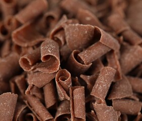 Many delicious chocolate shavings as background, closeup