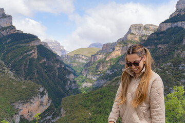 Woman with sunglasses and pigtails looks down in Anisclo Canyon