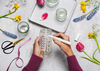 Step 3. Paint different flower motifs on a glass jar with white acrylic painter. Making spring...