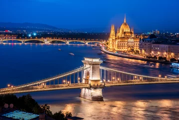 Photo sur Plexiglas Széchenyi lánchíd The picturesque landscape of the Parliament and the famous Szechenyi chain bridge over the Danube in the light of lamps in Budapest, Hungary.