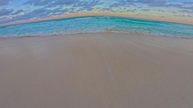 Vista en primera persona del mar caribe en el atardecer, cielo semi despejado con mar turqueza 