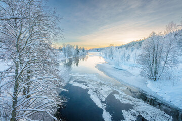 River flowing through the winter forest in Sweden