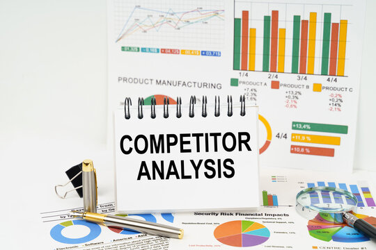 On the table are reports with graphs and a notepad with the inscription - Competitor Analysis