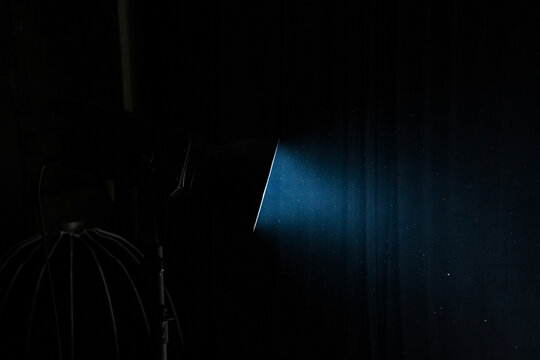 Spotlight with one studio light on dark background. Professional lighting equipment for photo studios.