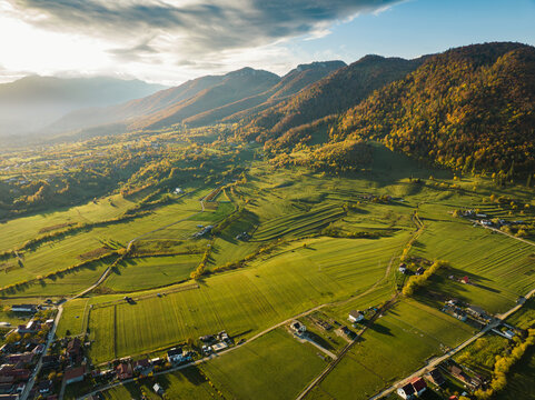 Aerial Footage of landscape morning ambiance at Village Zarnesti with green field and Piatra Craiului mountain as background. Drone footage Europe. 