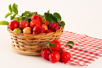 Fresh acerola fruits in a bamboo basket with in top view