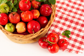 Fresh acerola fruits in a bamboo basket with in top view