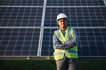 Indian man in uniform on solar farm. Competent energy engineer controlling work of photovoltaic...