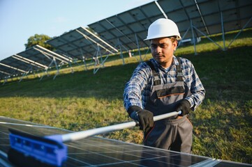 Indian worker cleaning solar panels