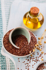 Brown linen seeds, flaxseed vegetable oil on white wooden background. Healthy super food