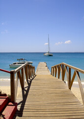 Naklejka premium St Marteens caribbean pier over beach with yacht in background