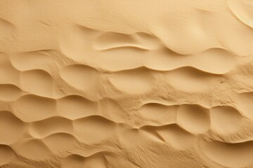 Fototapeta na wymiar a close up of a sand dune textured with wavy lines and a small amount of sand in the foreground.