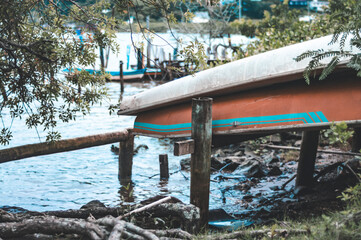 Boat turned down on the edge of a river on a cloudy day