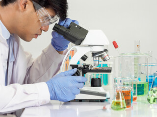 Portrait asian man student scientist Wearing a doctor gown in the lab looking hand at chemist....