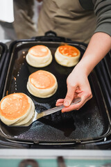 Meringue towers browning on a hot griddle, a delicate dessert in the making