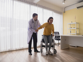 Portrait latin american woman sick sit wheelchair with man doctor caucasian sitting two people check and treat patients talk helping support explain medicine sick person inside hospital room service