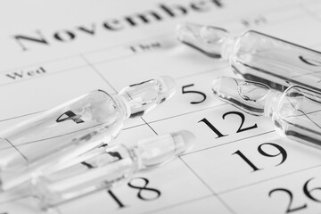 Medical ampoules on the background of a calendar. Medicines concept. Vials for medical injections