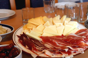 Homemade prosciutto and cut cheese on the table. Selective focus. Traditional Croatian food.
