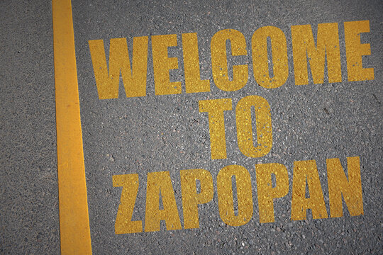 asphalt road with text welcome to Zapopan near yellow line.