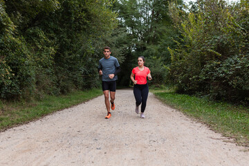 Fitness in Nature: Two Individuals Jogging on a Scenic Path