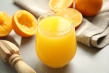 Freshly made juice, oranges and reamer on table, closeup - obrazy, fototapety, plakaty