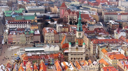 Aerial view of Poznan's historic market square in winter, showcasing the charming old townhouses...