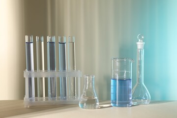 Laboratory analysis. Different glassware on table against color background