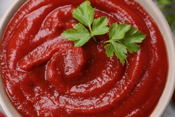 Organic ketchup and parsley in bowl, top view. Tomato sauce