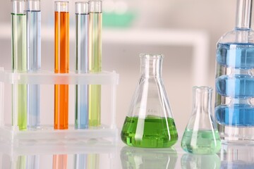 Laboratory analysis. Different glassware with liquids on white table against blurred background