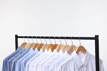 Dry-cleaning service. Many different clothes hanging on rack against white background, space for text
